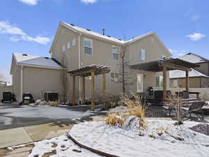 Snow covered property featuring central air condition unit, stucco siding, and a pergola