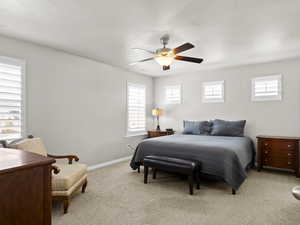 Bedroom with baseboards, ceiling fan, and light colored carpet