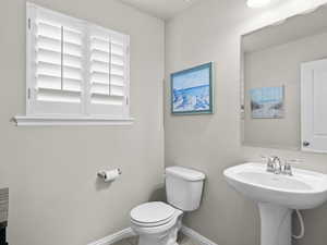 Bathroom with toilet, baseboards, and a sink