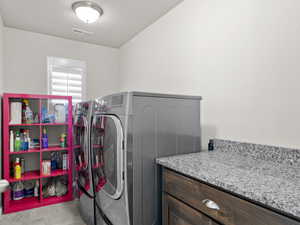 Laundry room with laundry area, visible vents, and washer and clothes dryer