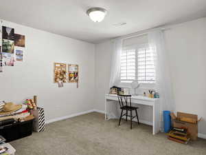 Carpeted office featuring visible vents and baseboards