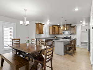 Dining room featuring recessed lighting, light wood-type flooring, and an inviting chandelier