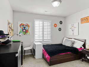 Bedroom with light carpet, visible vents, and baseboards