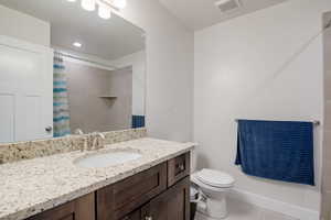 Bathroom with visible vents, a shower with shower curtain, toilet, tile patterned flooring, and vanity