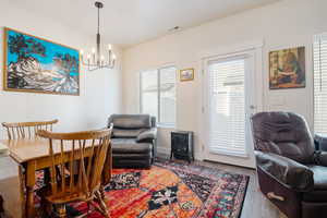 Interior space featuring visible vents, an inviting chandelier, a wood stove, wood finished floors, and baseboards