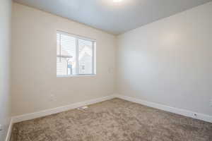 Spare room with carpet flooring, visible vents, and baseboards