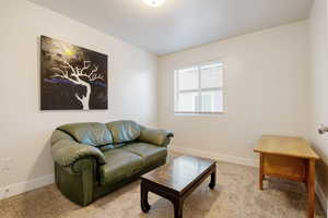 Carpeted living area featuring baseboards