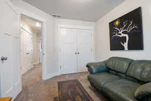 Carpeted living room featuring visible vents and baseboards