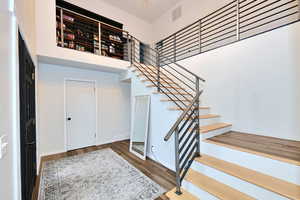 Staircase featuring visible vents, baseboards, and wood finished floors