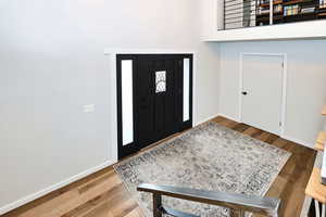 Foyer with baseboards and wood finished floors