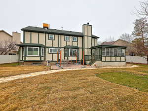 Back of house featuring a patio, a sunroom, a chimney, fence, and a yard