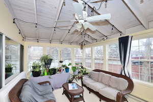 Sunroom / solarium with a baseboard heating unit, wood ceiling, a ceiling fan, and vaulted ceiling with beams