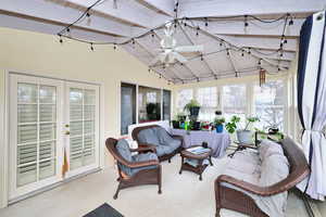 Sunroom / solarium featuring french doors, ceiling fan, and lofted ceiling with beams