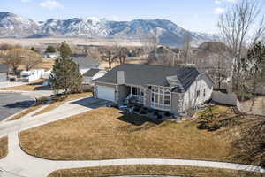 View of front of property featuring driveway, a garage, fence, a mountain view, and a front lawn