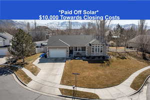 Single story home with concrete driveway, an attached garage, fence, and a mountain view