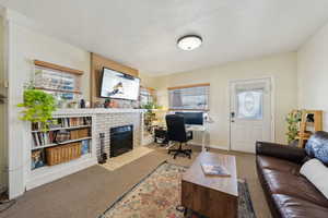 Living room with a brick fireplace and light colored carpet