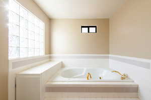 Bathroom featuring a textured ceiling and a garden tub