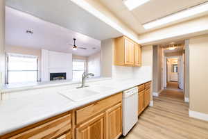 Kitchen with visible vents, decorative backsplash, dishwasher, light brown cabinets, and a sink