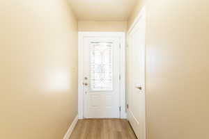 Entryway with light wood-type flooring and baseboards