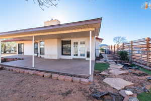 Rear view of house with a patio, french doors, fence, and stucco siding