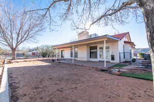 Exterior space with a gate, a patio area, fence, and stucco siding