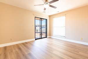 Empty room featuring light wood-style flooring, baseboards, and a textured ceiling