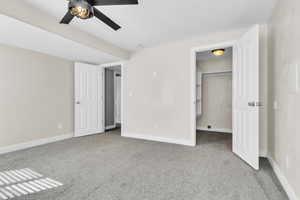 Unfurnished bedroom with carpet flooring, a spacious closet, and baseboards