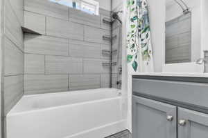 Bathroom featuring shower / bath combo with shower curtain and vanity