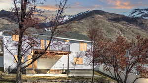 Exterior space with entry steps, a mountain view, a balcony, and a patio