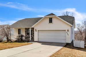 Traditional home with covered porch, roof with shingles, fence, and concrete driveway