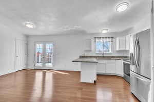 Kitchen with stainless steel appliances, french doors, a sink, and white cabinets