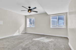 Unfurnished room featuring carpet floors, baseboards, and a ceiling fan