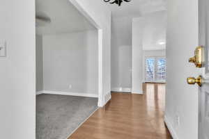 Carpeted foyer featuring french doors, wood finished floors, and baseboards