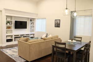 Living room featuring built in features, a high ceiling, and dark wood-type flooring