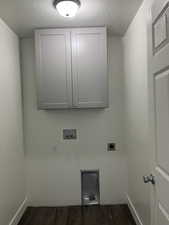 Washroom featuring cabinet space, hookup for an electric dryer, hookup for a washing machine, and dark wood finished floors