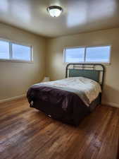 Bedroom with wood finished floors and baseboards