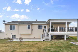 Back of property with a patio area, a lawn, and stairs