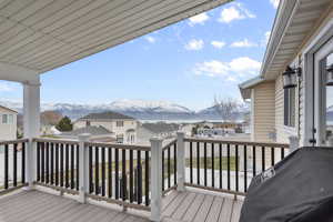 Wooden deck featuring a lake view and a mountain view