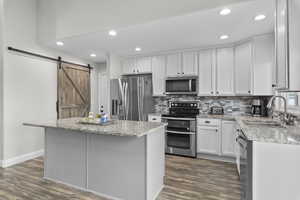 Kitchen with stainless steel appliances, granite counter top.  Pantry with a barn door