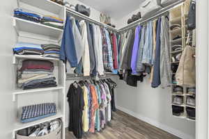 Spacious walk-in closet with wood finished floors