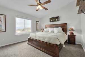 Primary Bedroom with carpet, lofted ceiling, and baseboards