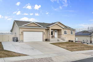 Ranch-style home with concrete driveway, an attached garage, a gate, fence, and stucco siding