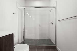 The primary bathroom features a walk-in shower with a penny-tiled floor and subway-tiled walls.