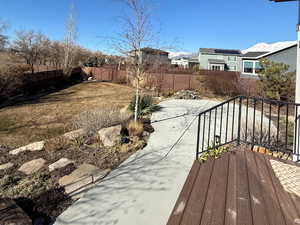 Wooden terrace featuring a fenced backyard and a patio