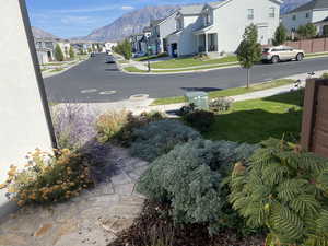 View of road with a mountain view, curbs, sidewalks, and a residential view in summer