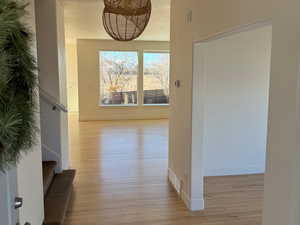 Corridor featuring stairway, visible vents, light wood-style flooring, and baseboards