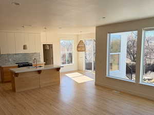 Kitchen with a breakfast bar, light countertops, decorative backsplash, a sink, and modern cabinets