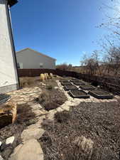 View of yard featuring a garden and fence