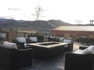 View of patio with outdoor dining space, a mountain view, and an outdoor living space with a fire pit