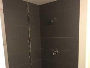 Full bath featuring a stall shower and a textured ceiling